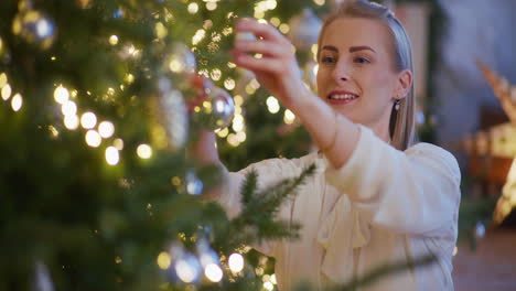 mujer sonriente decorando el árbol de navidad