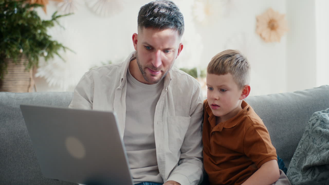 un niño y su padre pasan tiempo juntos en la computadora.