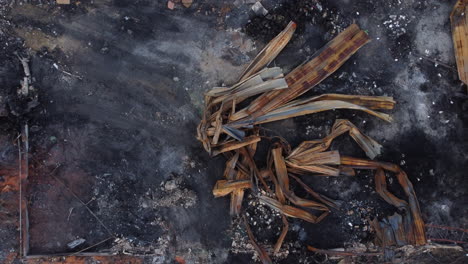 Aerial-ascend-birds-eye-of-burnt-warehouse-area-after-strong-fire---Smoky-ash-field-and-broken-bricks