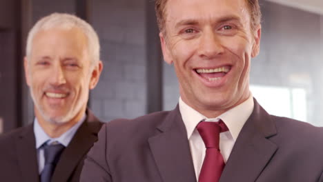 hombres de negocios sonrientes posando con los brazos cruzados