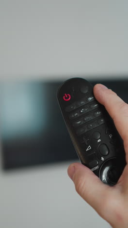 persona de canal navegando con un control remoto de tv, árbol de navidad en el fondo, pov con una cámara de mano