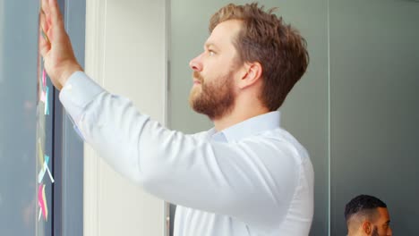 arquitecto masculino poniendo notas adhesivas en vidrio 4k