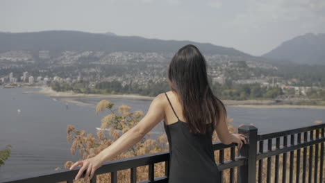 young asian girl enjoying view at prospect point, vancouver north shore in background, slowmo