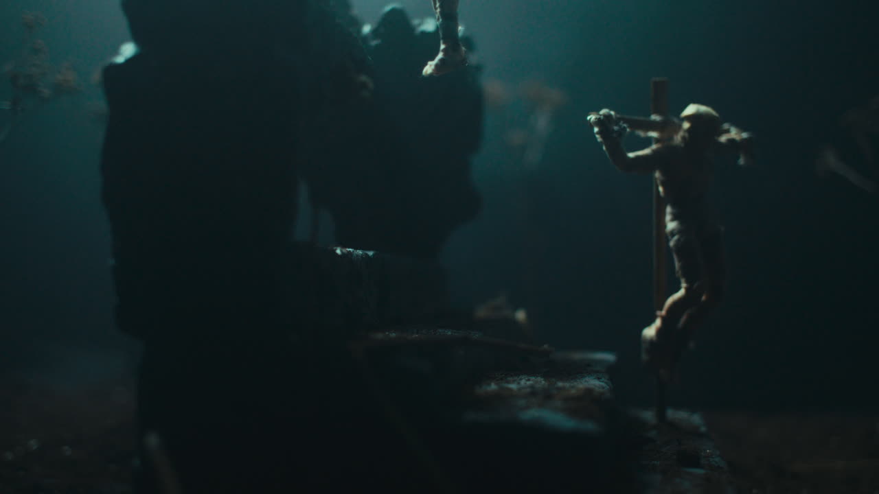 A miniature mummified doll hanging on the gallows at night