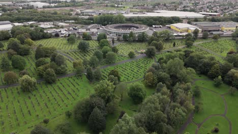 High-angle-aerial-dolly-shot-over-verdant-Philips-Park-Cemetery,-Manchester,-UK