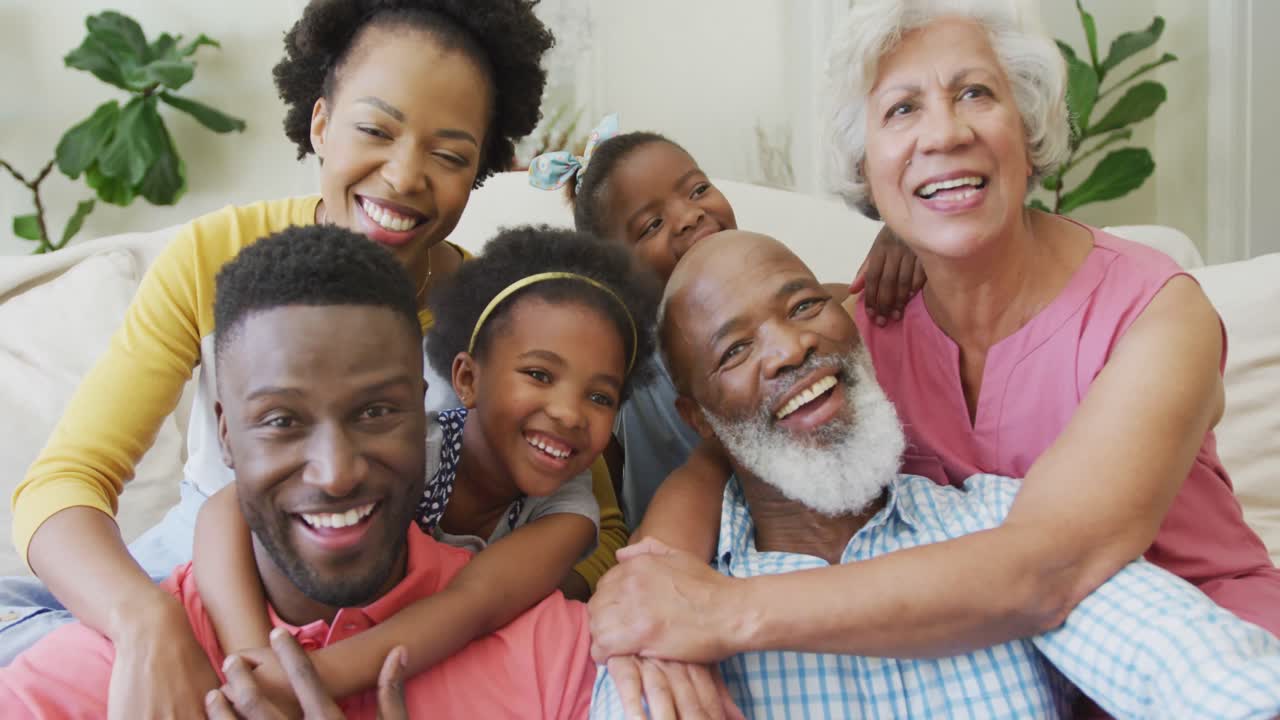 Portrait of happy african american family embracing in living room