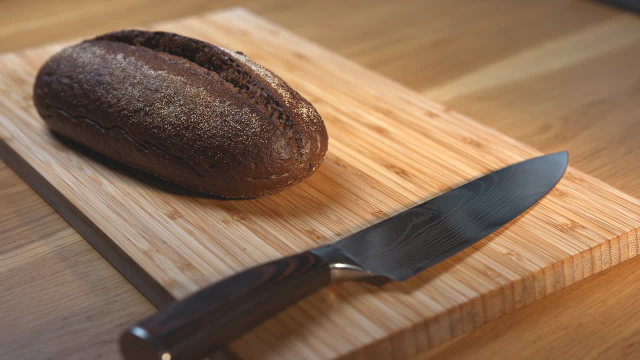Dark Bread and Knife on Cutting Board
