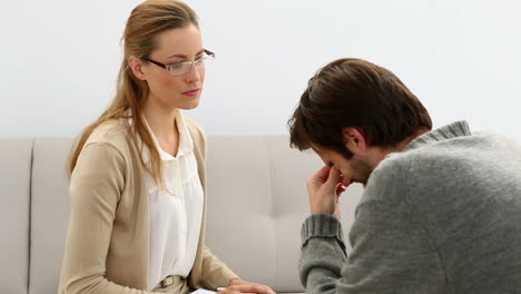 Young-man-sitting-on-sofa-talking-to-his-therapist