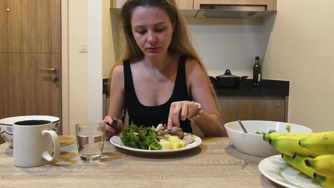 A woman is eating a healthy salad
