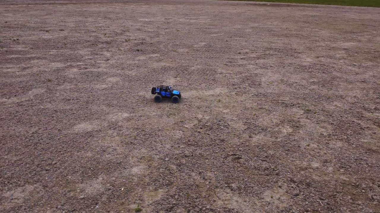소형 4x4 트럭 경주 가 거친 지형 을 가로질러, 공중 에서 높은 각도 에서 드론 으로 관찰 된다