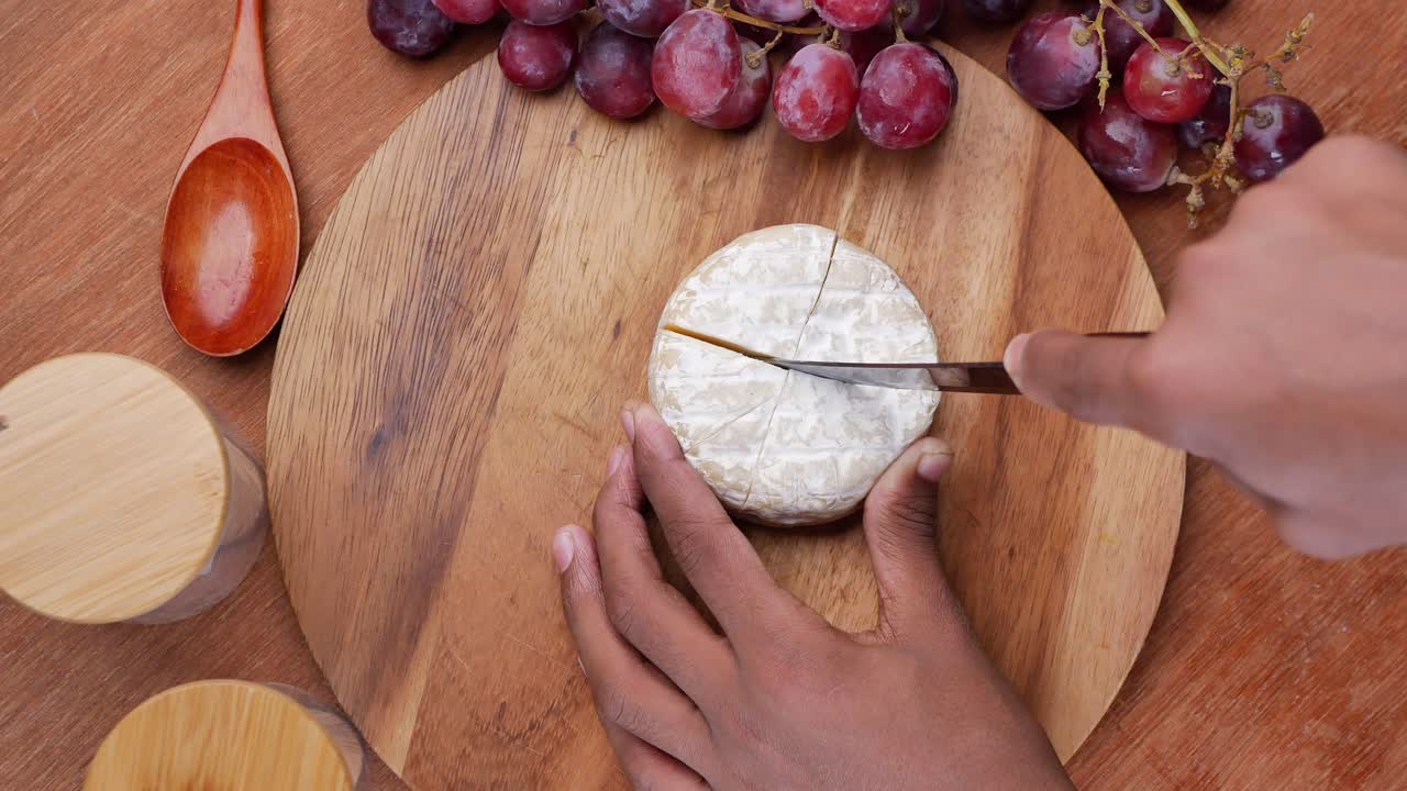 cortando una rueda de queso en una tabla de madera