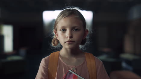 Closeup-scared-girl-standing-empty-school-hall.-Teen-child-holding-notebook.