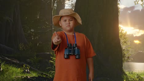 niño asiático con un sombrero y binoculares apuntando su dedo hacia usted y sacudiendo la cabeza agitando el dedo índice evitar oferta mientras explora la naturaleza del bosque. niño investigador que no muestra ningún gesto