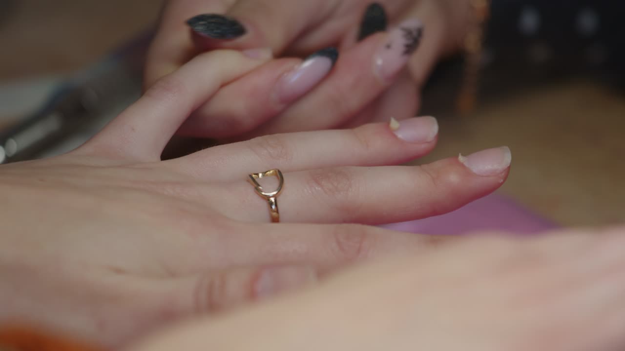 Manicurista massaggia olio per cuticole nella pelle intorno alle unghie, primo piano