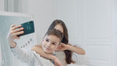 smiling boy and girl making fun for selfir photo together.