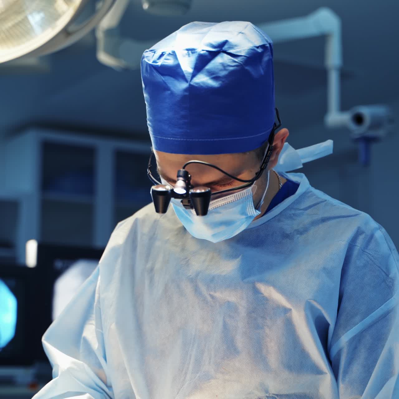 Doctor with surgical flashlight on head. Professional doctor in medical cap and uniform conducts a neurosurgery in operating room. Operating theater.