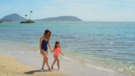 mother and daughter walking on the beach 4k