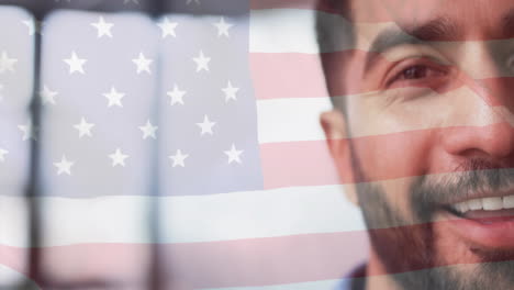 animation of flag of usa over happy indian businessman in office