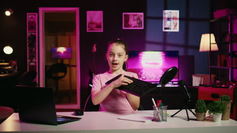 cute child hosting internet show promueve teclado y ratón inalámbricos recibidos de la marca patrocinadora