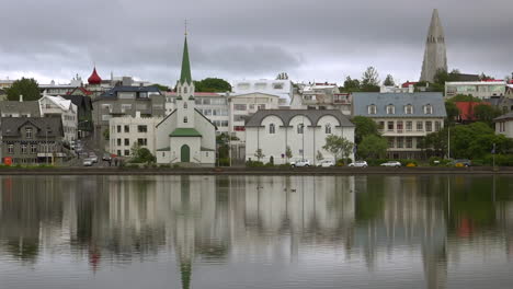 Establishing-shot-of-Reykjavik-Iceland-reflected-in-a-lake