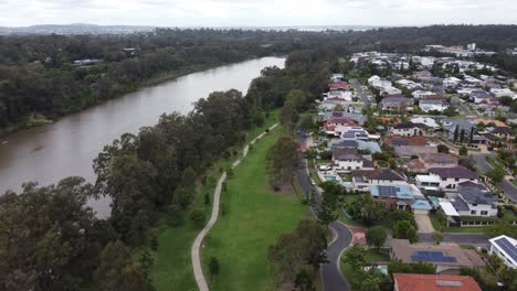 aerial view of a residential suburb near a brown river and a green park in australia