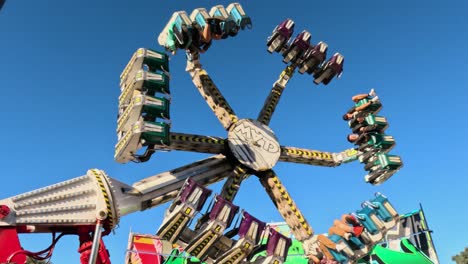 a rotating ride at a fair with excited passengers.