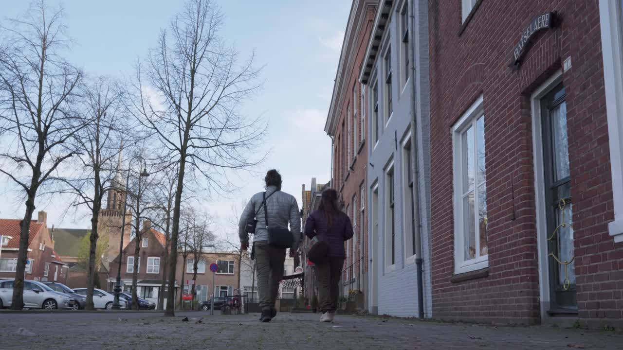 Quaint Dutch town, traditional homes, people exercise, community street