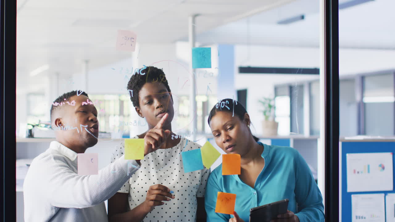 Professionisti afroamericani che fanno brainstorming e usano il tablet in ufficio, al rallentatore.