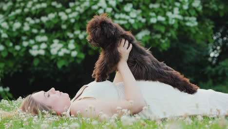 Active-Pregnant-Woman-Is-Playing-With-Her-Dog-In-The-Backyard-Of-The-House-Lying-On-The-Lawn