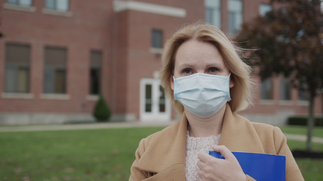 retrato de una maestra en el fondo del edificio de la escuela