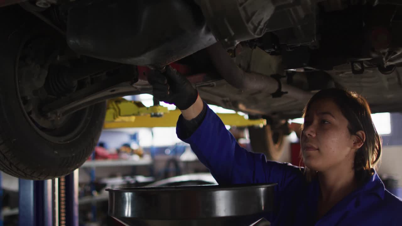 mecánica cambiando el aceite del coche en una estación de servicio de coches