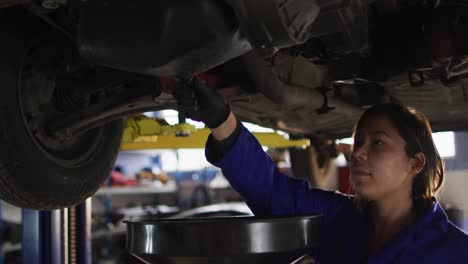 Female-mechanic-changing-oil-of-the-car-at-a-car-service-station