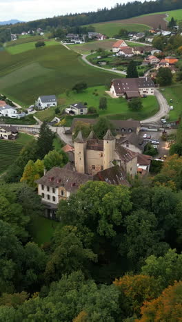 vertical, aerial: dolly in drone shot of vaumarcus castle during the day in canton of neuchatel, switzerland