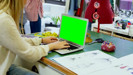diseñador de moda usando una computadora portátil en un estudio de moda 4k