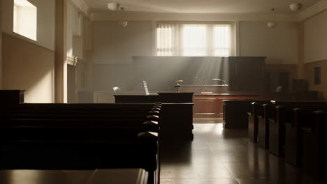 empty courtroom with sunlit window and benches