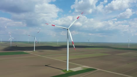 aerial view of several windmills, wind generators, turbines, producing renewable clean energy by converting kinetic energy
