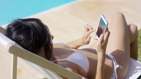 Young-woman-browsing-on-a-mobile-in-the-summer-sun