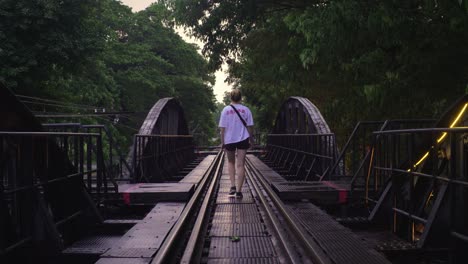 Mujer-Joven-Caminando-Sobre-Las-Vías-Del-Tren-En-El-Ferrocarril-De-La-Muerte-En-Kanchanaburi,-Tailandia