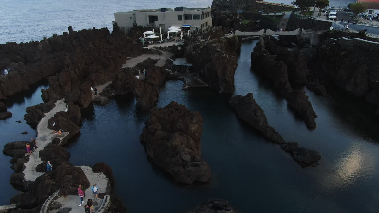 toma aérea que revela las hermosas piscinas naturales de la ciudad de porto moniz en la isla de madeira