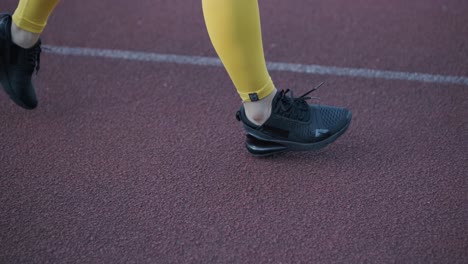 female athlete running on outdoor track in sportswear