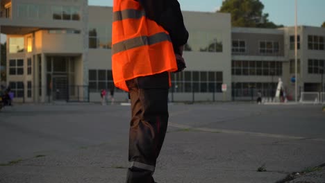 security officer holding two-way radio and wearing bright high-visibility vest standing in the street