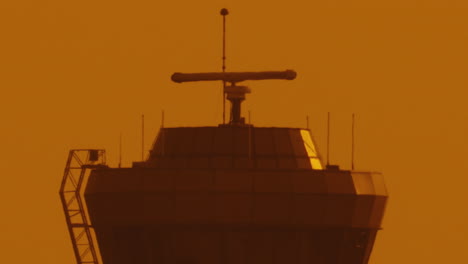 Un-Primerísimo-Plano-De-La-Torre-De-Control-Del-Tráfico-Aéreo-En-El-Aeropuerto-Al-Atardecer-Con-Cielo-Naranja