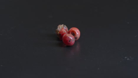 pink berries spice, close up black backround