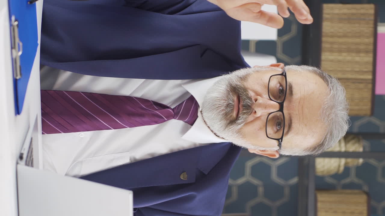 Lodret video af ældre forretningsmand, der kigger ind i kameraet med undren og forvirring
