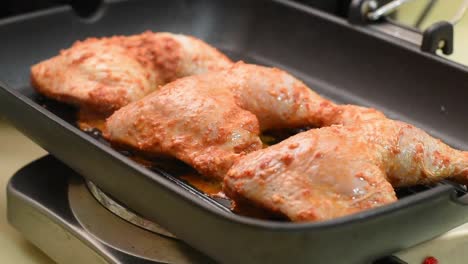 girar el pollo peri-peri mientras se asa a la parrilla en la sartén al vapor