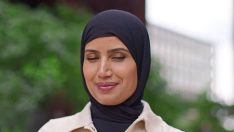 retrato en primer plano de una mujer de negocios musulmana sonriente con hijab y traje de negocios fuera de los edificios de oficinas modernos 2