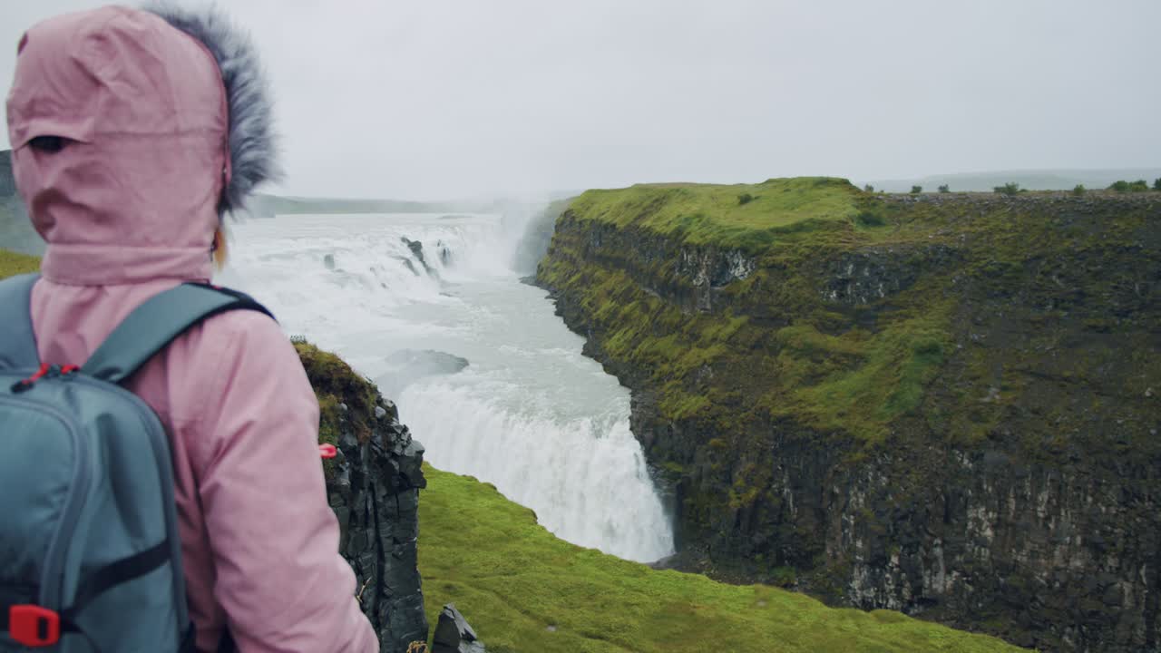 mujer turista mirando la cascada de gullfoss la famosa atracción y destino histórico de islandia en el círculo dorado
