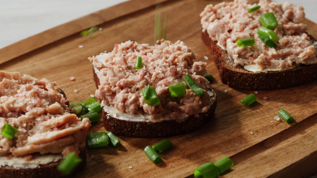 Smoked cod liver in oil in open tin can with fresh greens on wooden table. Seafoods delicacy. High quality 4k footage