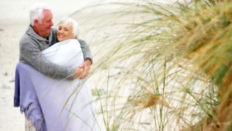senior couple embracing each other on the beach