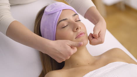 mulher recebendo uma massagem facial em um spa